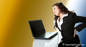 a person Sitka bending over a computer holding her back due to pain